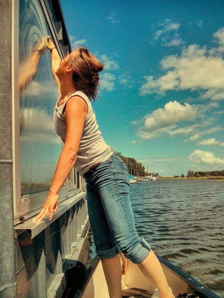 Fenster putzen am Hausboot an der Ostsee